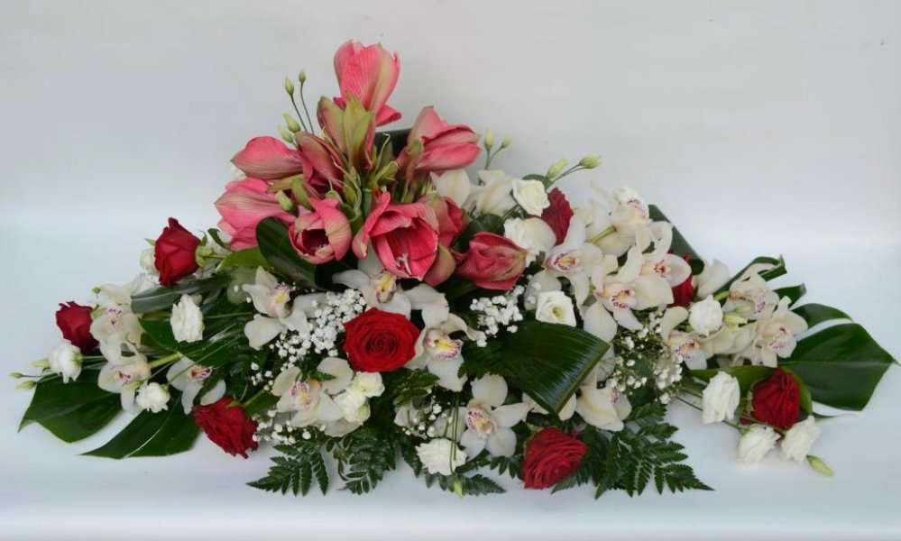 Composizione per funerale con orchidee, rose e fiori eleganti.