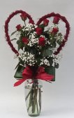 Rose rosse in una cornice a forma di cuore.
